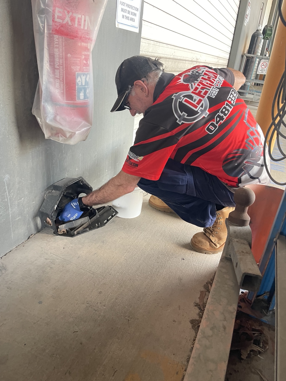 Lethal Pest Control technician servicing an external rodent station